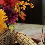 harvest flower arrangement and candle on a table