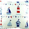 white, red and blue nautical cushion with boats, beach huts and lighthouses
