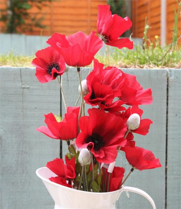 artificial poppy stems in a jug